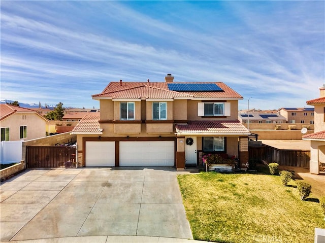 view of front of home with a front yard, a garage, and solar panels