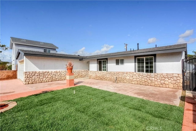 rear view of house featuring a yard and a patio