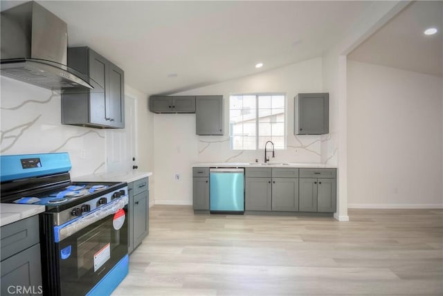 kitchen with sink, ventilation hood, vaulted ceiling, gray cabinets, and stainless steel appliances