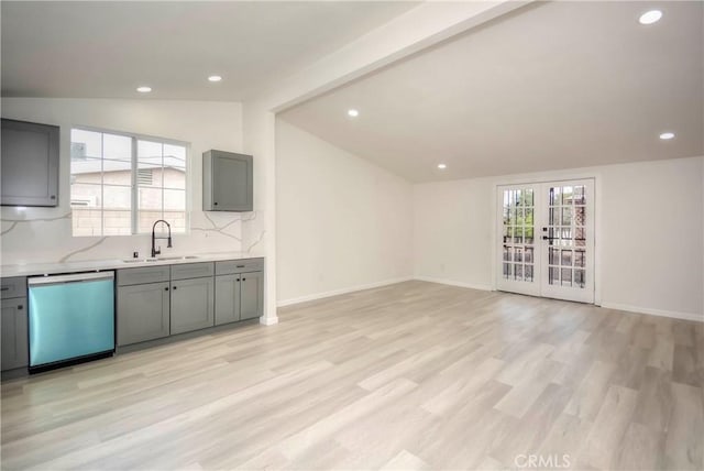 kitchen with french doors, sink, vaulted ceiling, stainless steel dishwasher, and gray cabinets