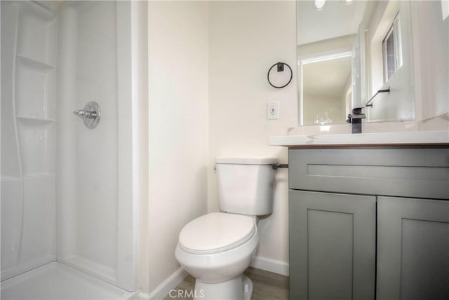 bathroom with a shower, vanity, and toilet