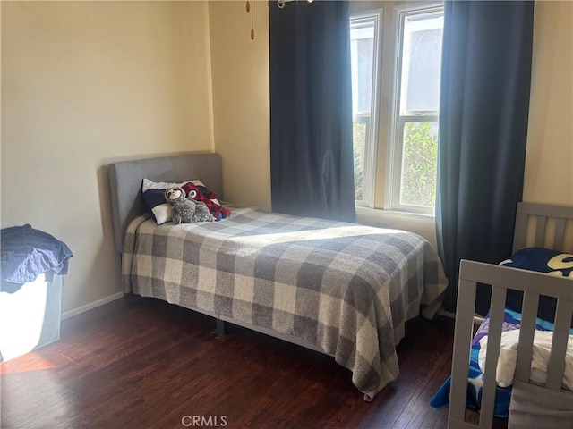 bedroom featuring dark wood-type flooring and baseboards