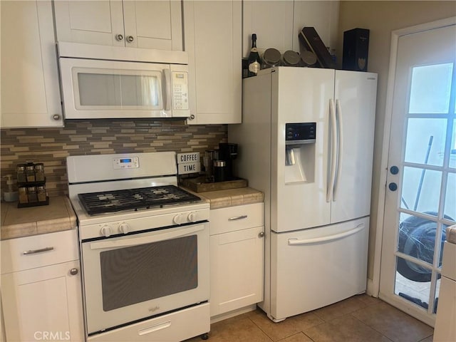 kitchen featuring white appliances, white cabinetry, backsplash, and light tile patterned flooring