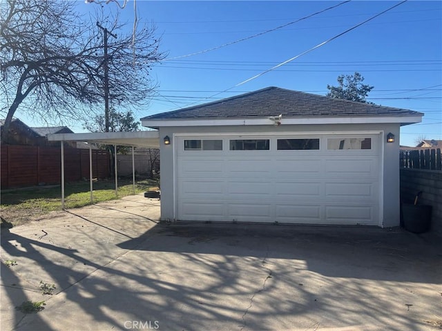 detached garage featuring fence