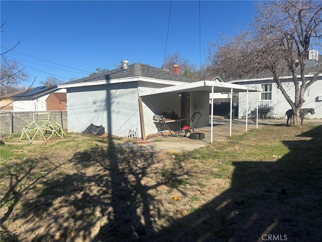 back of property featuring fence, a patio, and a yard