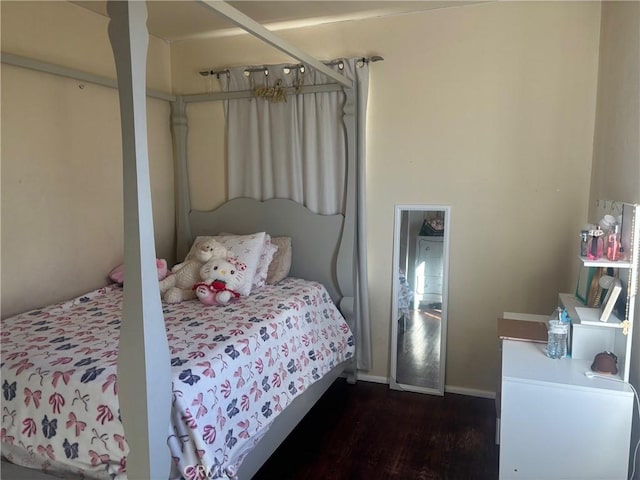 bedroom with dark wood finished floors and baseboards