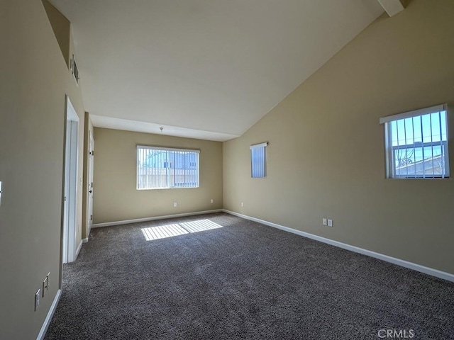 carpeted spare room featuring high vaulted ceiling