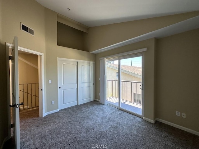 unfurnished bedroom with lofted ceiling, carpet floors, a closet, and access to outside