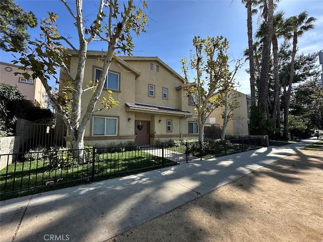 view of front of home featuring a fenced front yard and stucco siding