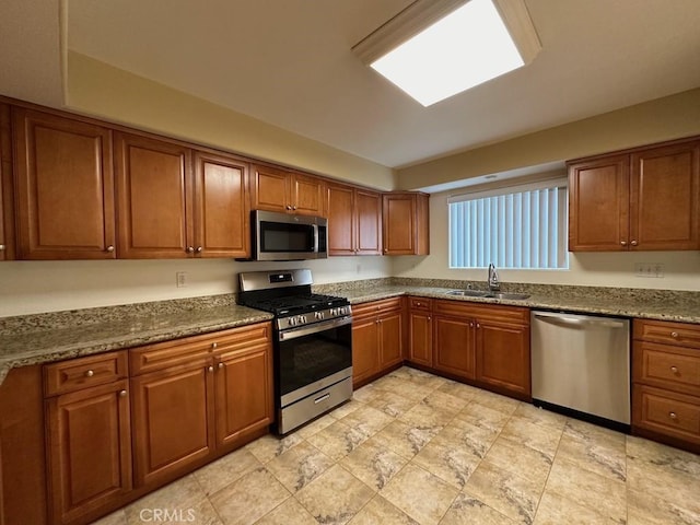 kitchen with dark stone countertops, sink, and stainless steel appliances