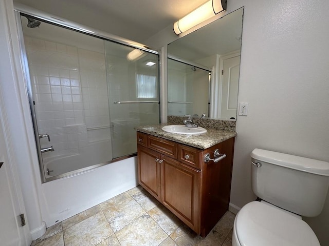 full bathroom with vanity, bath / shower combo with glass door, and toilet