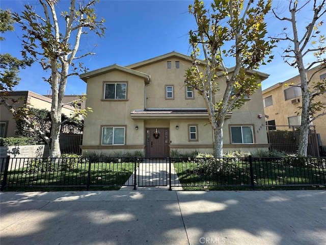 view of front of home with a fenced front yard and stucco siding