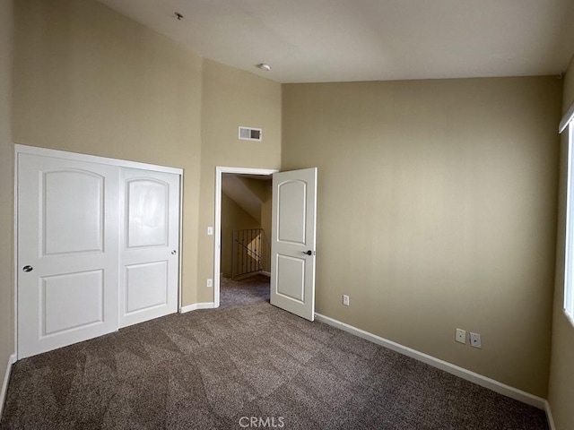 unfurnished bedroom with vaulted ceiling and carpet flooring