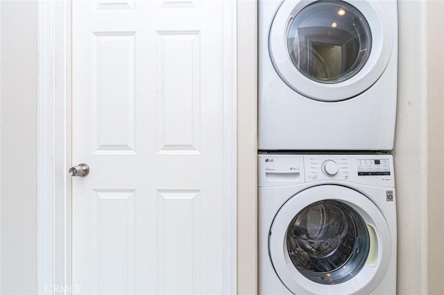 laundry room with stacked washer / drying machine and laundry area