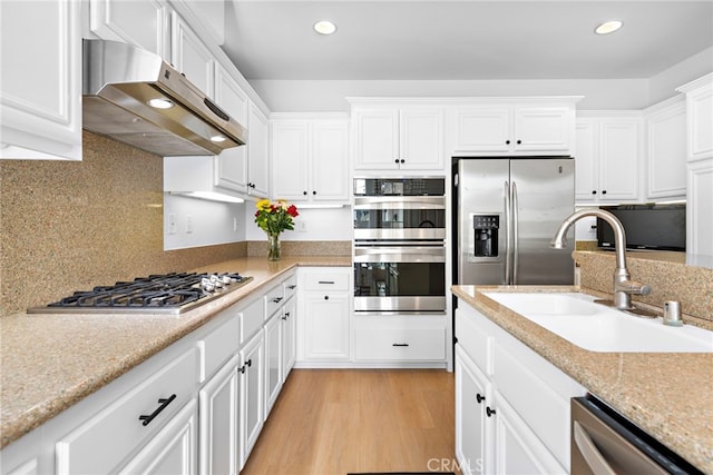 kitchen featuring sink, light hardwood / wood-style flooring, white cabinetry, stainless steel appliances, and decorative backsplash