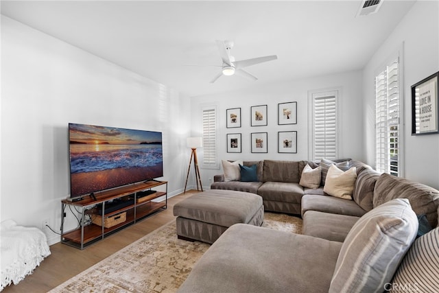 living room with light hardwood / wood-style flooring and ceiling fan