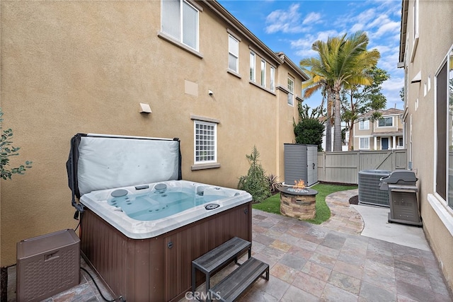 view of patio featuring a hot tub, central AC, grilling area, and an outdoor fire pit