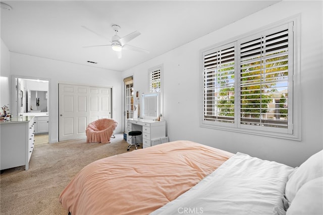 bedroom featuring light colored carpet, a closet, and ceiling fan