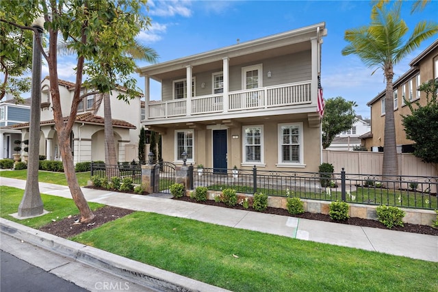 view of front of house featuring a balcony and a front yard