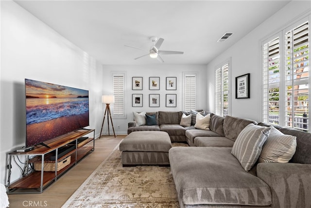 living room featuring ceiling fan and light hardwood / wood-style flooring