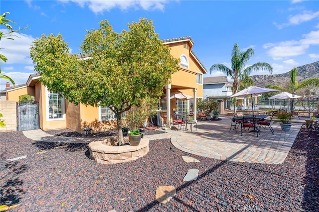 back of house with a mountain view and a patio area