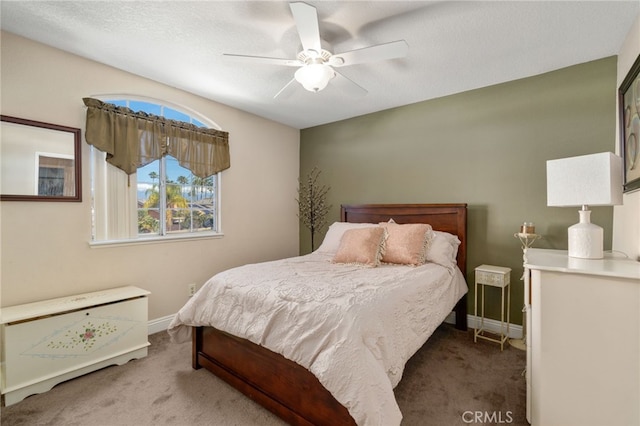 carpeted bedroom featuring ceiling fan and a textured ceiling