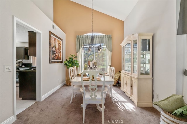 dining space with high vaulted ceiling, a chandelier, and light colored carpet