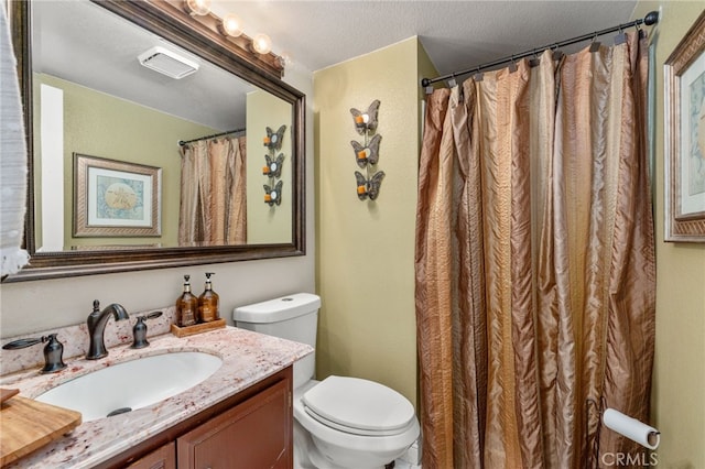 bathroom featuring vanity, toilet, and a textured ceiling