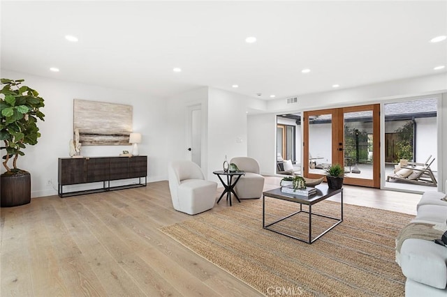 living room featuring visible vents, baseboards, recessed lighting, light wood-style flooring, and french doors