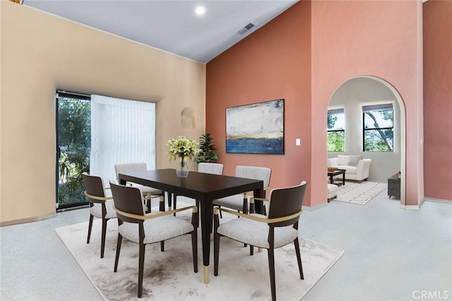 dining space with high vaulted ceiling