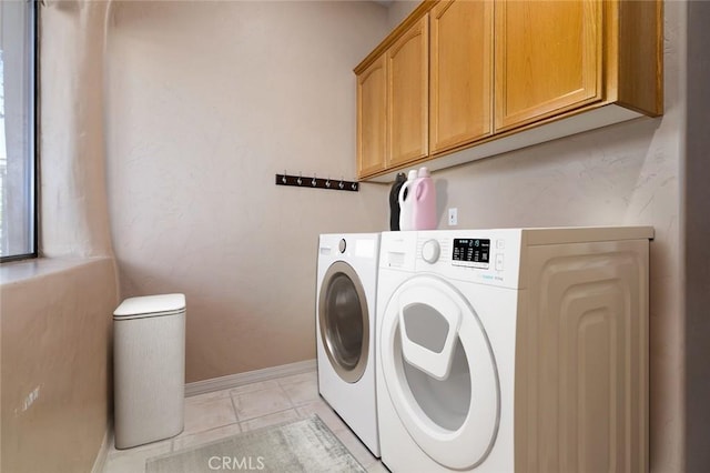 laundry area featuring cabinets, washing machine and dryer, and light tile patterned floors