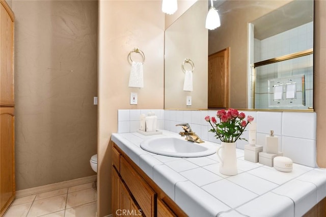 bathroom with vanity, tasteful backsplash, tile patterned floors, and toilet