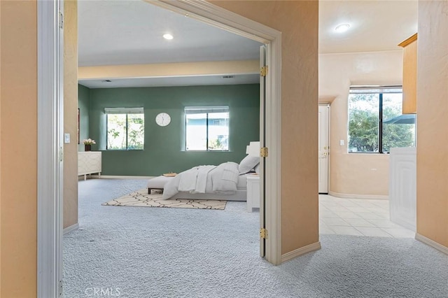 hallway featuring a healthy amount of sunlight and light carpet