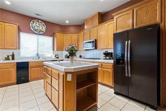 kitchen featuring tile countertops, light tile patterned floors, a kitchen island, and black appliances