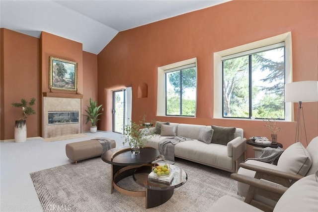 carpeted living room featuring lofted ceiling and a tiled fireplace