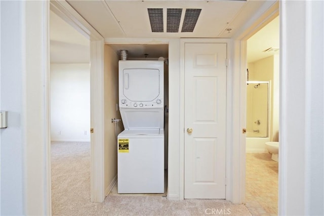 laundry room with stacked washer and clothes dryer and light carpet