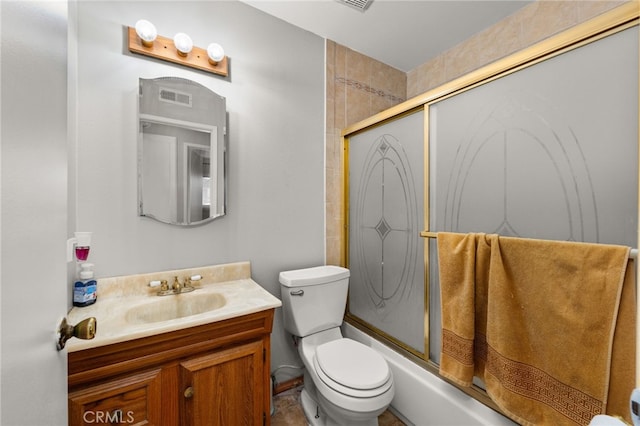 full bathroom with enclosed tub / shower combo, vanity, and toilet