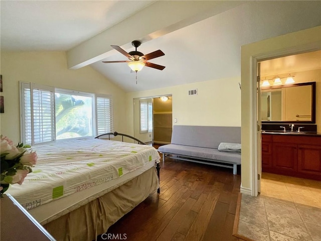 bedroom with ensuite bath, vaulted ceiling with beams, sink, ceiling fan, and light wood-type flooring