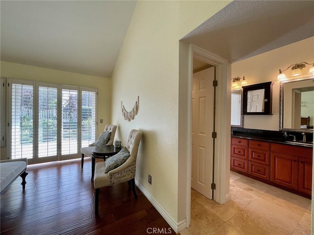 sitting room featuring sink and high vaulted ceiling