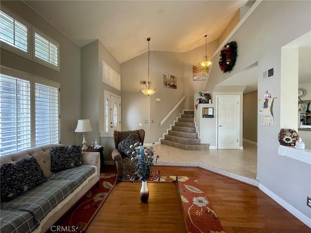 living room with hardwood / wood-style floors, high vaulted ceiling, and a healthy amount of sunlight