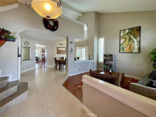 living room featuring high vaulted ceiling, light tile patterned floors, and beam ceiling