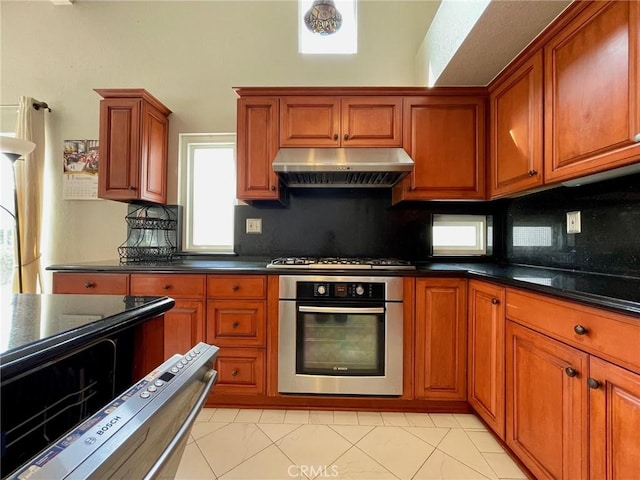 kitchen featuring appliances with stainless steel finishes, decorative backsplash, and dark stone counters