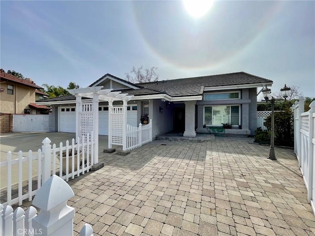 view of front facade featuring a garage and a pergola