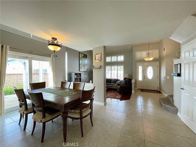 tiled dining room featuring a textured ceiling