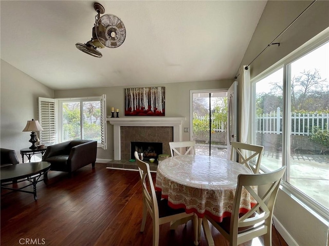 dining space featuring a tile fireplace, lofted ceiling, and a wealth of natural light