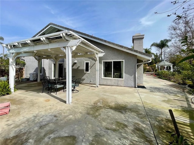 rear view of property featuring a gazebo and a patio