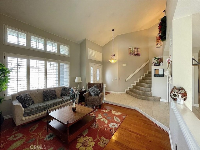 living room with wood-type flooring and high vaulted ceiling