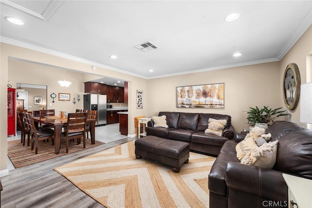 living room featuring light wood-type flooring and crown molding