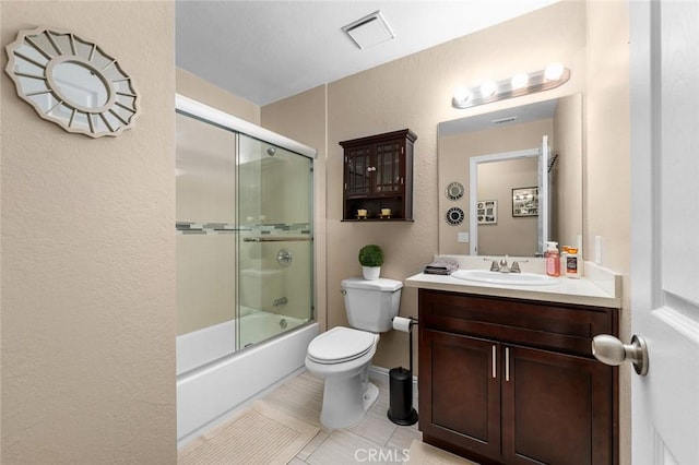 full bathroom with enclosed tub / shower combo, vanity, tile patterned flooring, and toilet