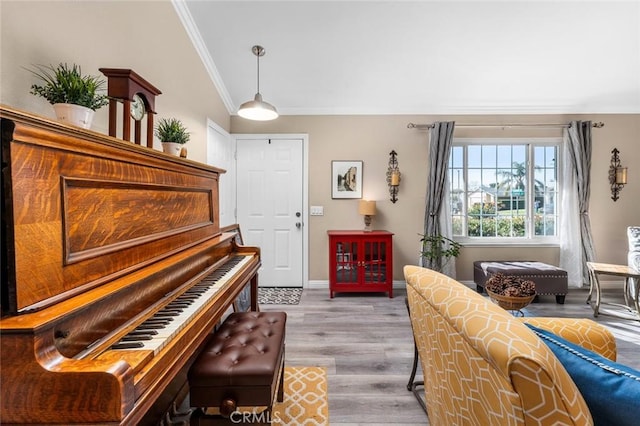 sitting room featuring light wood-type flooring, crown molding, and lofted ceiling